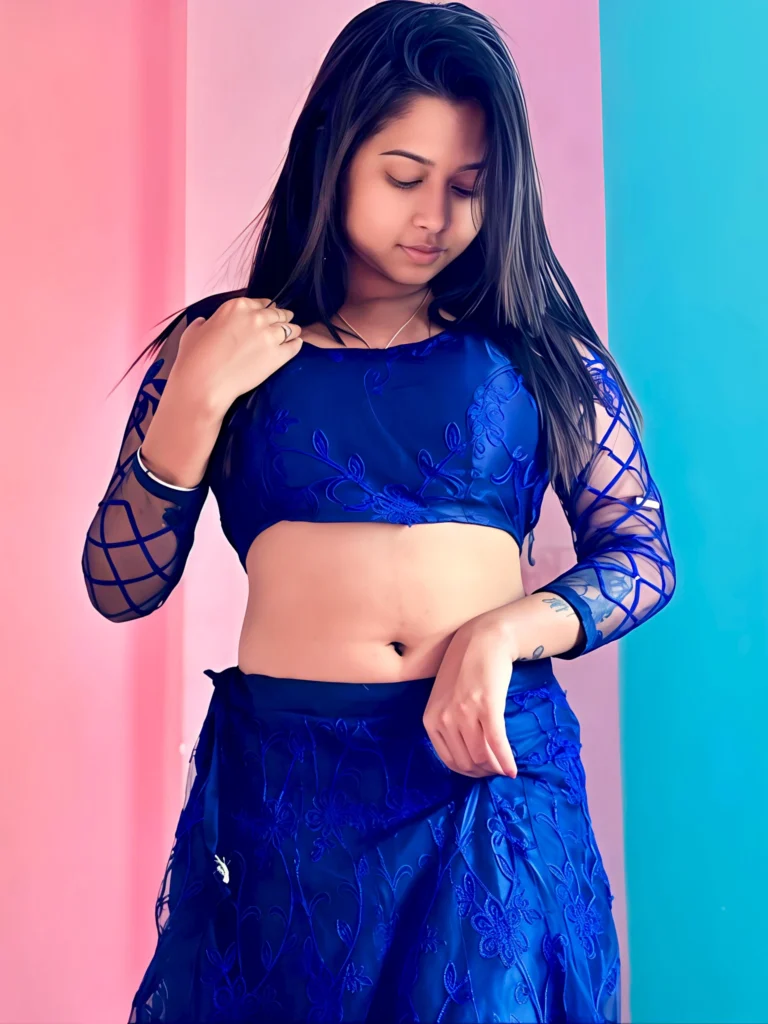 Friendly Escort Riya seated gracefully in a cozy indoor setting